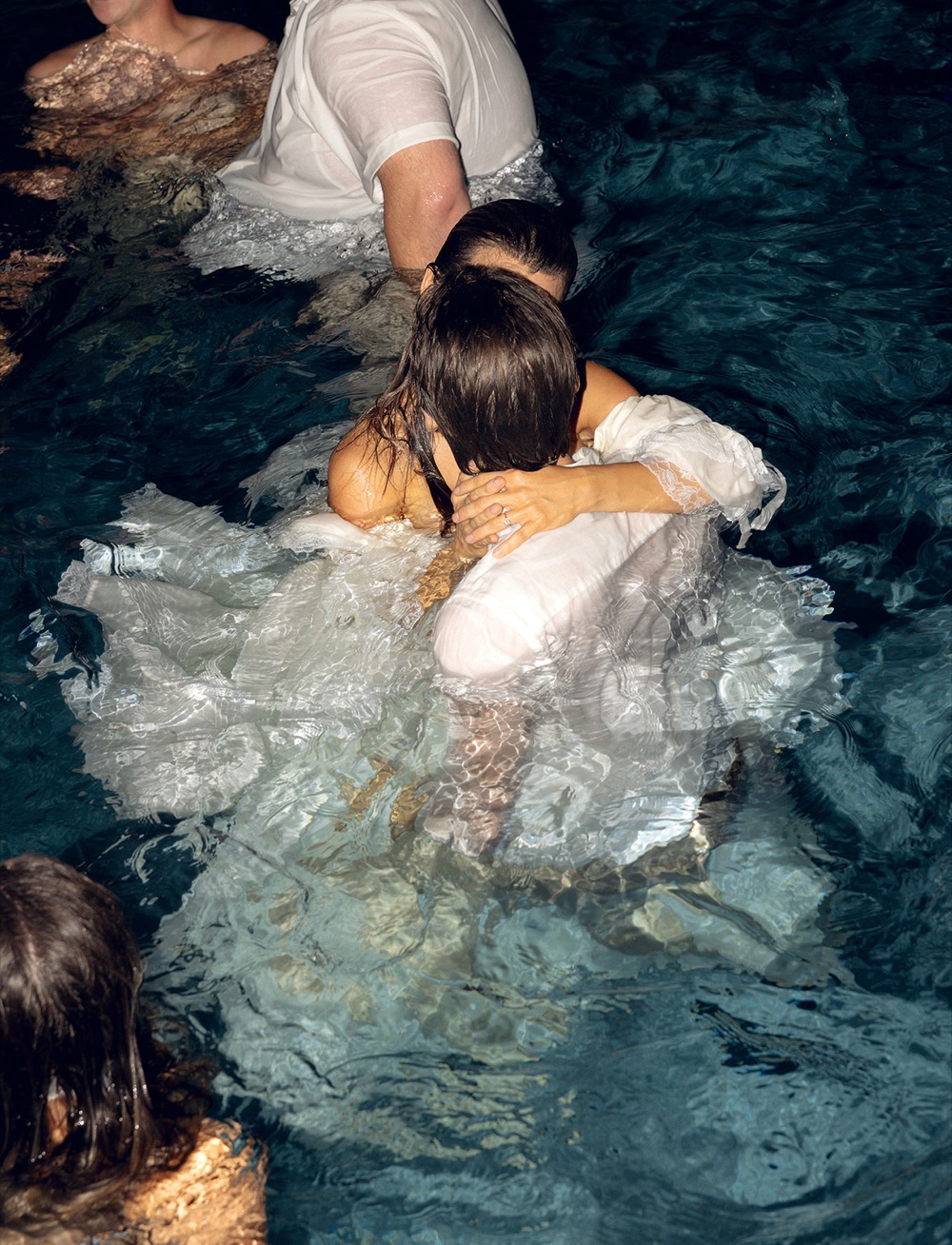 The bride and groom in the pool after the party