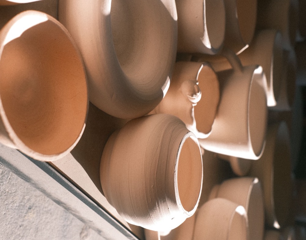 Throw Studio — unglazed bowls and mugs on a drying tray