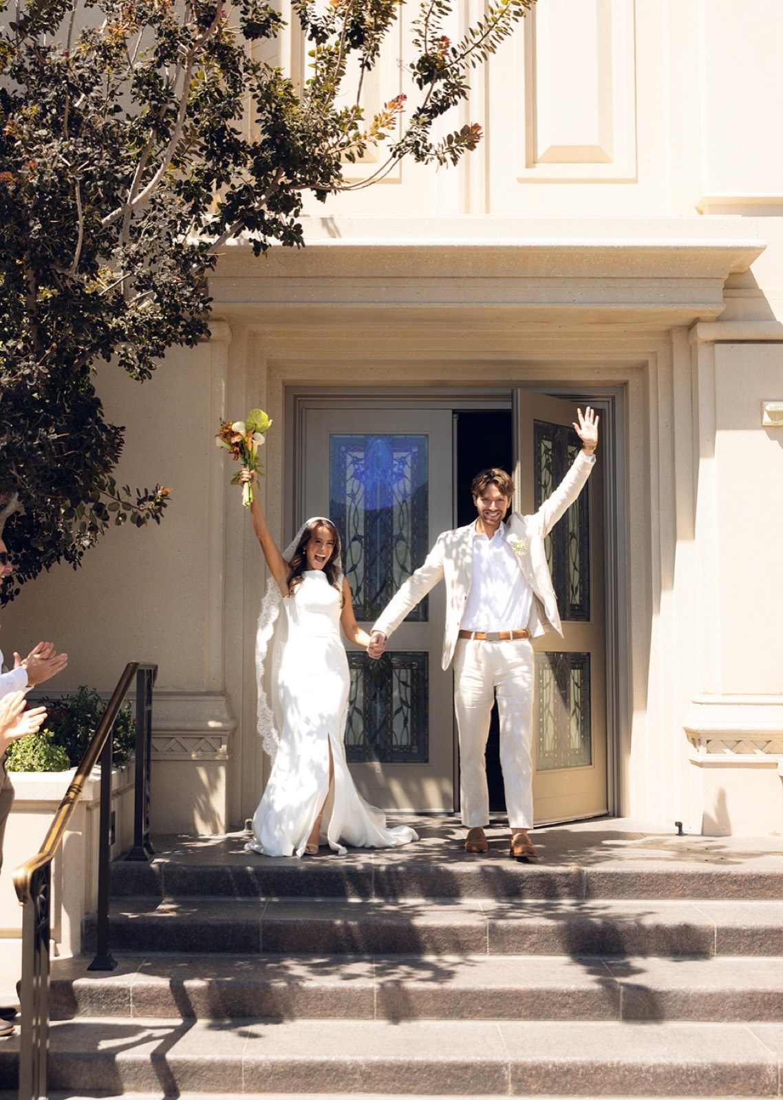 Cheering as the couple walks out of the temple doors