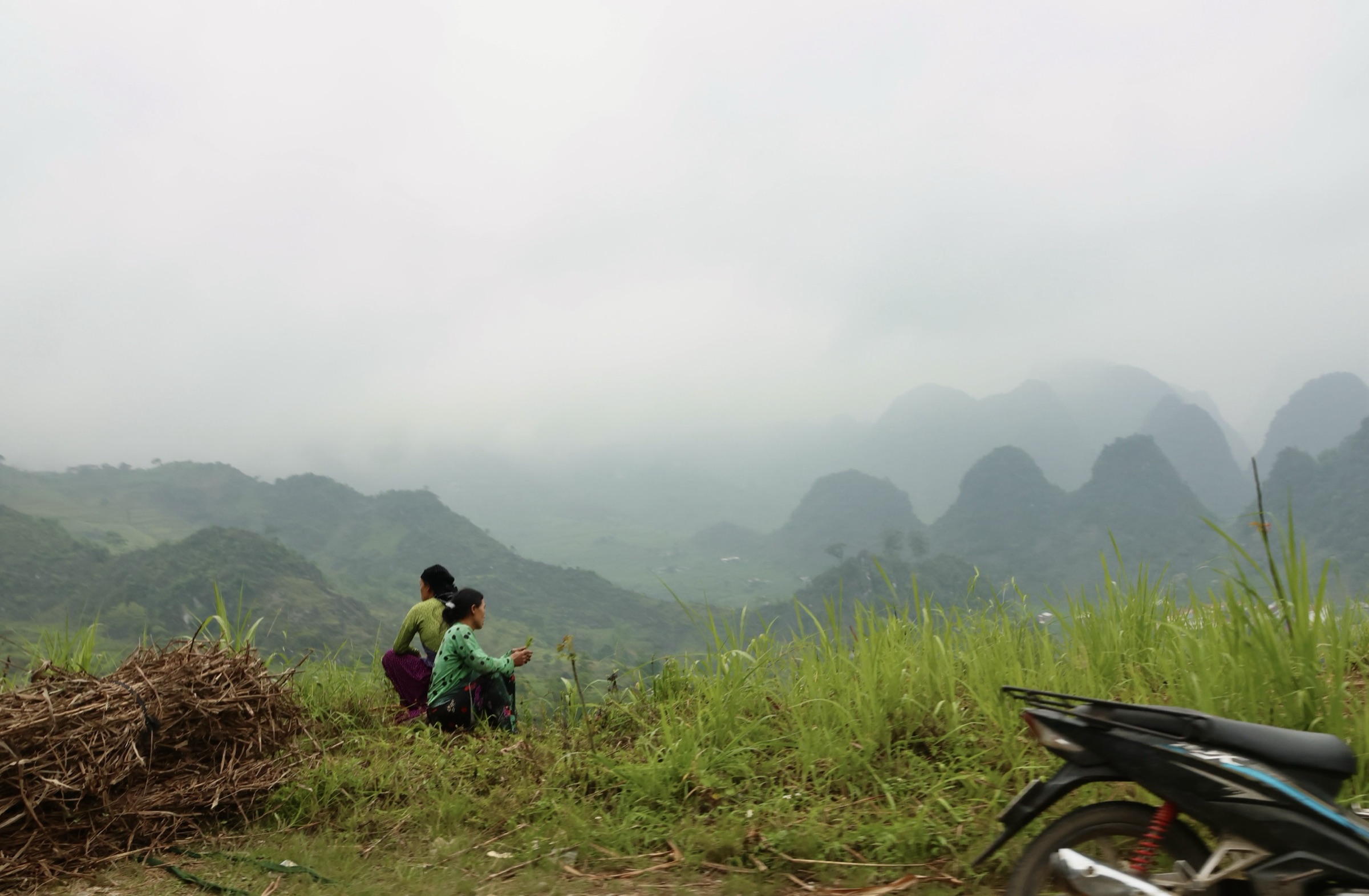 Two women looking out over misty karst hills