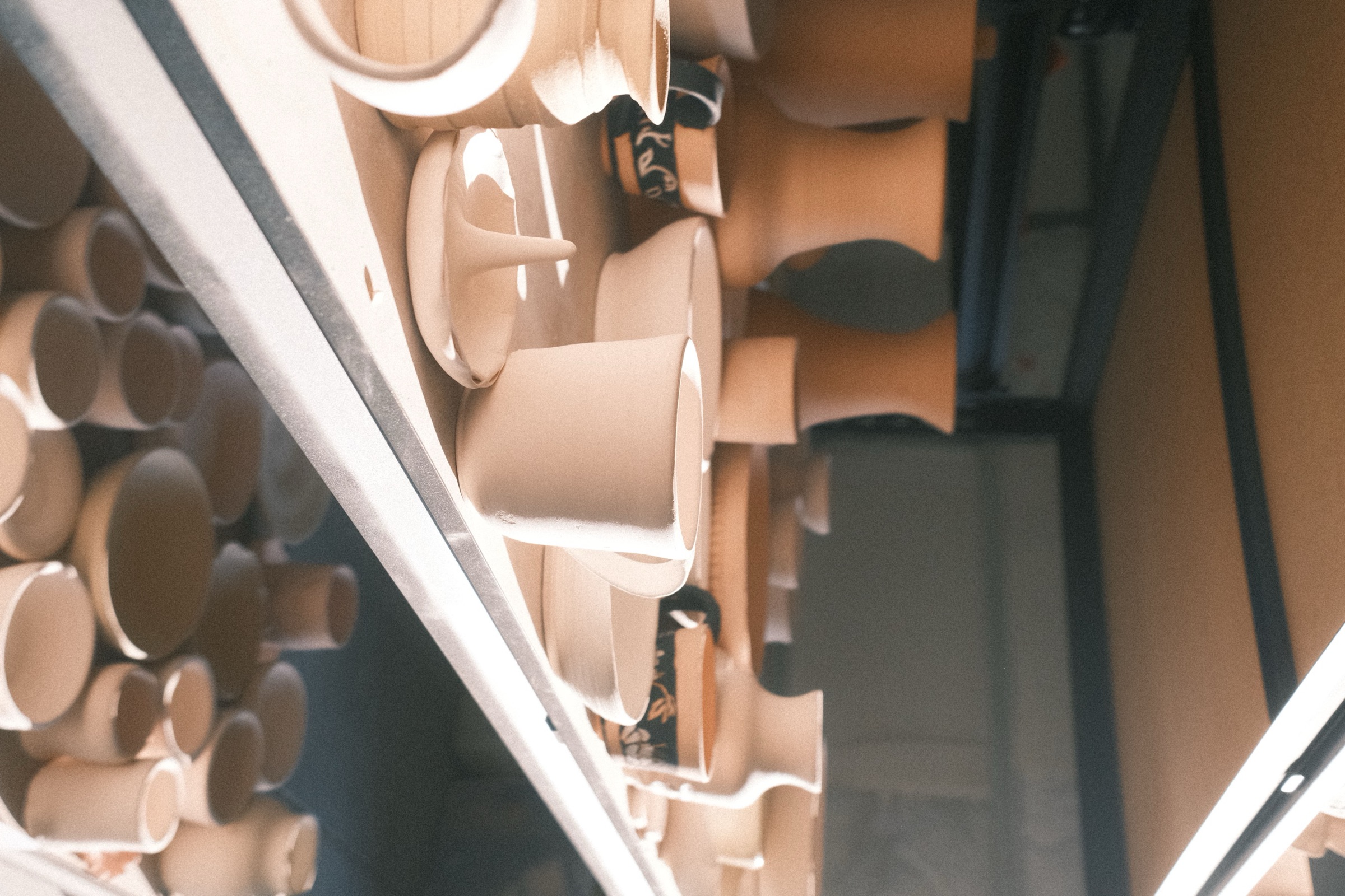 Throw Studio — shelves of unglazed pottery drying in the studio