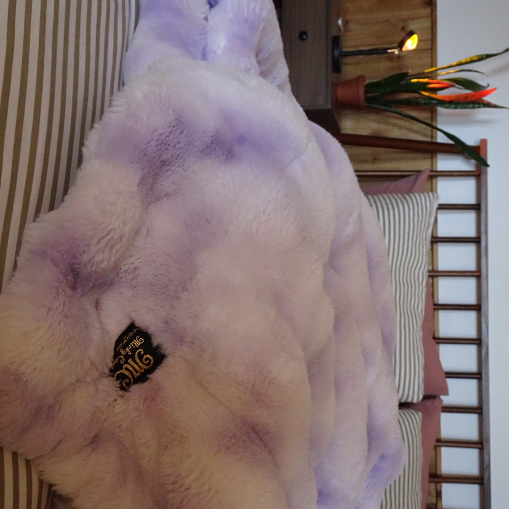 A lavender Minky blanket laid across a bed